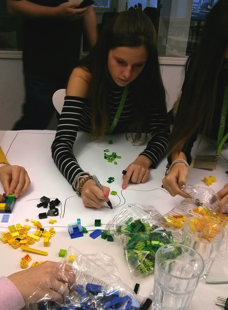 Une jeune fille dessine les chemins du parc tandis que d'autres construisent avec les Legos pendant un atelier de la journée futur en tous genres