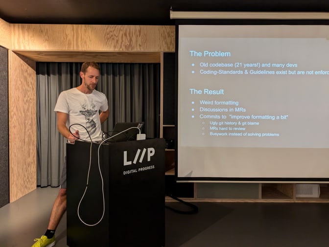 Pablo presenting at the Liip Arena, slides on the big screen on the left