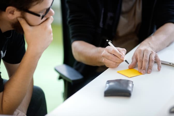 Person writing on a postit